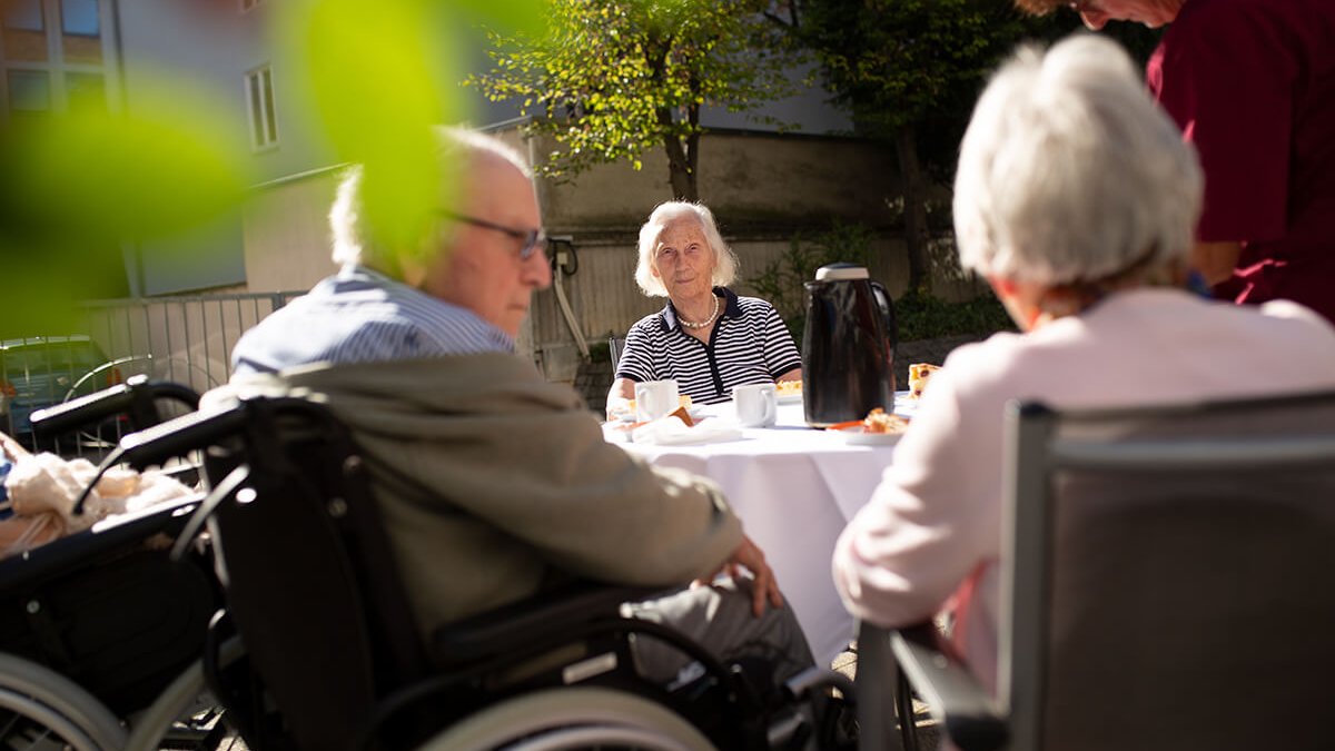 Senioren beim Kaffeetrinken im Brunnenhof